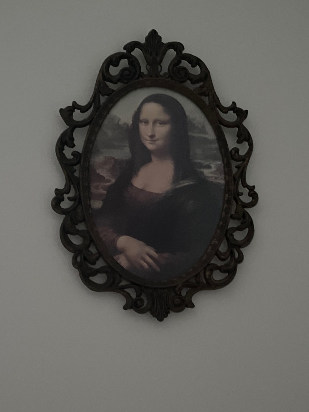 Mona Lisa housed in ornate metal frame 10”x7”